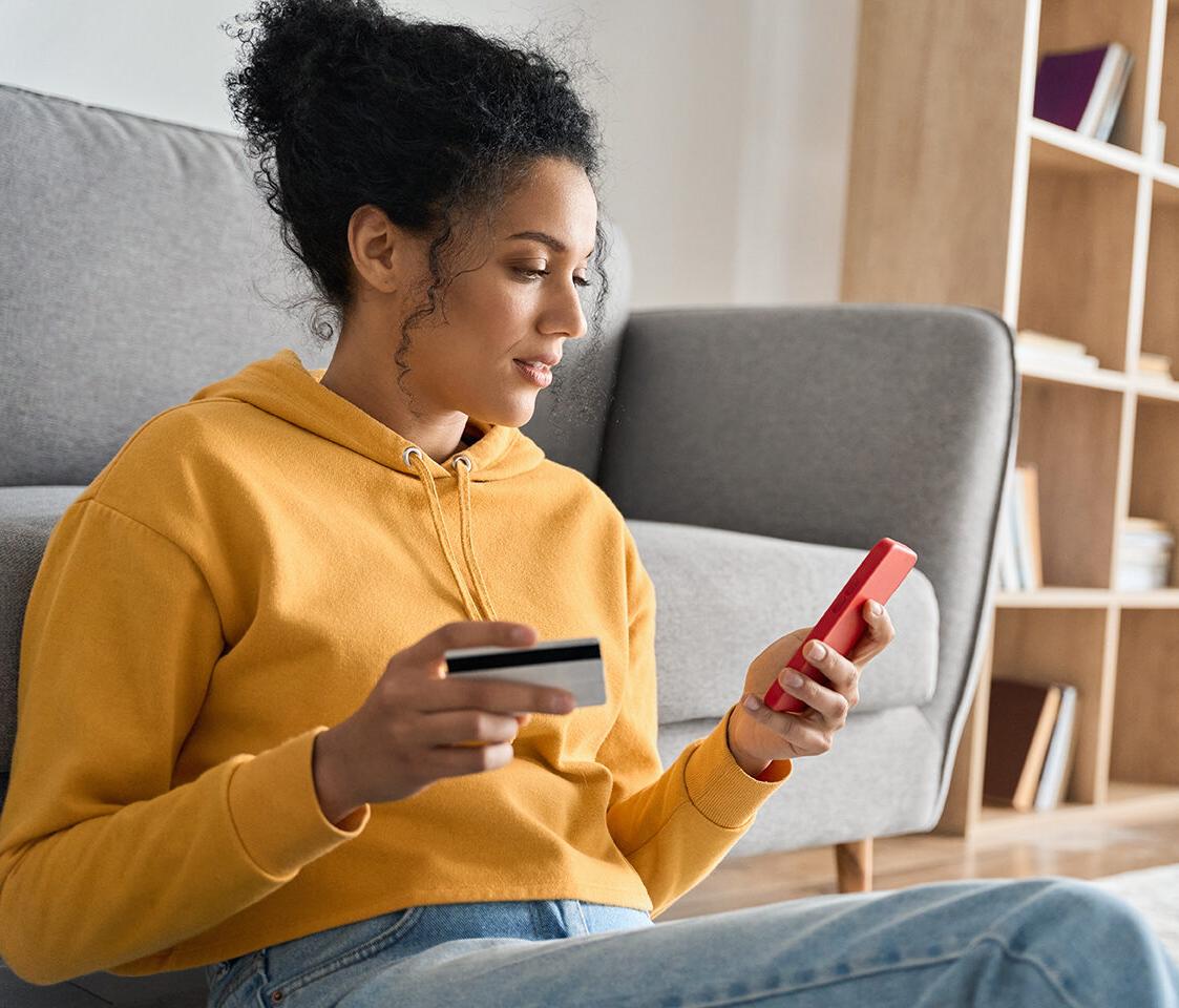 Image of a woman looking at her phone and card